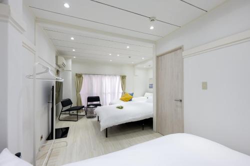 ein Hotelzimmer mit 2 Betten und einem Schreibtisch in der Unterkunft LUANAHOTEL IN YOTSUYA in Tokio