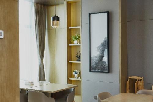 a dining room with a table and a mirror at Zenith Hotel-Near Train Station & The Mixc in Xiamen
