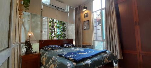 a bedroom with a bed in a room with a window at Green Homestay in Hanoi