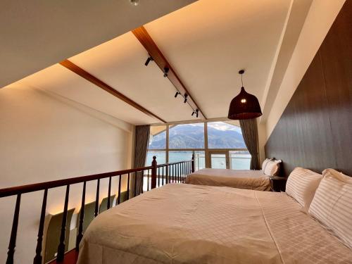 a bedroom with two beds and a balcony with a view at Ming Hu B&B in Yuchi