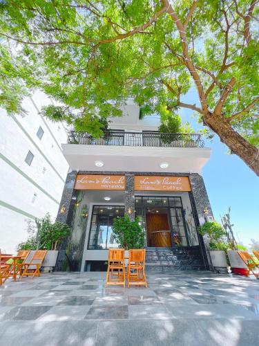 a building with chairs and trees in front of it at Lam's Beach Homestay in Phan Thiet