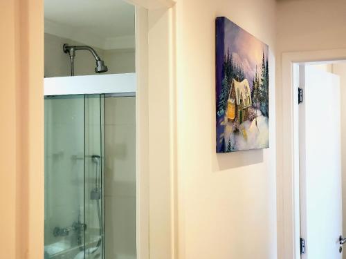 a bathroom with a shower and a painting on the wall at Apê Novo em Sampa Prox do Tietê Plaza in Sao Paulo