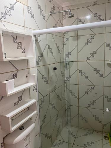 y baño con ducha y puerta de cristal. en Apartamento Familiar e aconchegante, en Maragogi