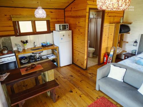 a kitchen with a refrigerator and a couch in a room at UN SUEÑO LOFT in Punta Del Diablo