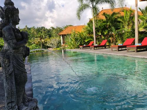 una estatua junto a una piscina con una fuente en Alamdhari Resort and Spa, en Sidemen