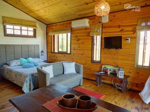 1 dormitorio con cama, sofá y TV en UN SUEÑO LOFT, en Punta del Diablo