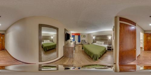 Una habitación de hotel con una cama y un espejo grande. en Hometown Inn Thomasville, en Thomasville
