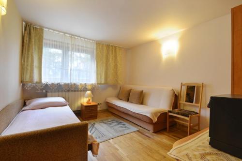 Habitación con 2 camas, sofá y ventana en Muran Apt en Zakopane