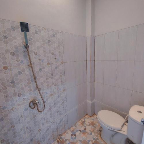 a bathroom with a toilet and a shower at TM 16 Padang - Mentawai Tour Package, Airport Transport, Sumatra Local Touch in Padang