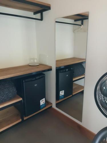 a closet with wooden shelves and a mirror at Pousada Sítio Vale das Olivas in Aiuruoca