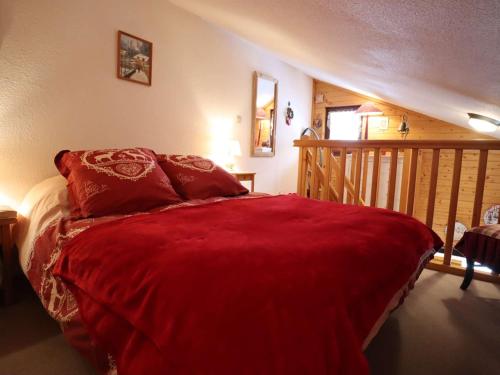 une chambre avec un lit avec une couverture rouge dans l'établissement Studio cosy avec mezzanine, 27m², 2/3 pers, Équipé, Wifi, Balcon, Proche ski et commerces - FR-1-342-293, à Beaufort