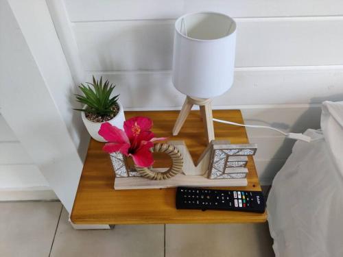 a bedside table with a lamp and a remote control at Keshy island eden in Baillif