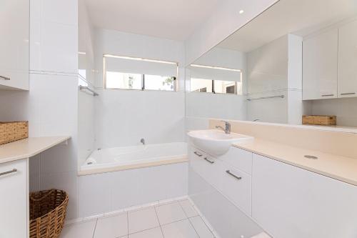 a white bathroom with a sink and a mirror at Marine Drive in Forster