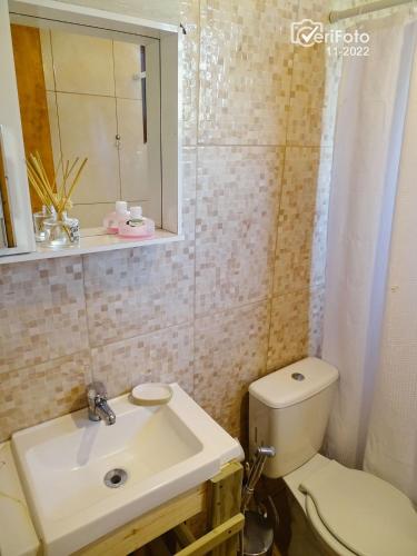a bathroom with a toilet and a sink and a mirror at Un Sueño 2 in Punta Del Diablo