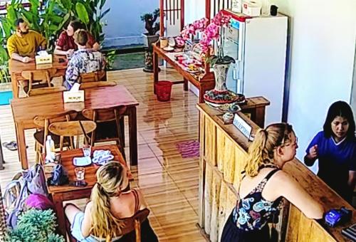 ペニダ島にあるDouble'D Hostelの店の席に座る人々