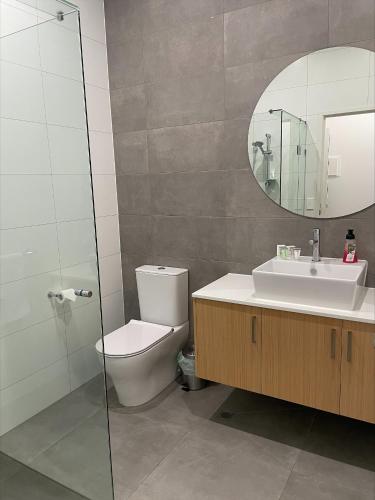 a bathroom with a toilet and a sink and a mirror at Whittlesea Motel in Whittlesea