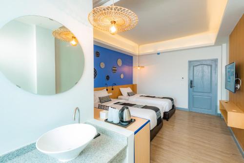 Habitación de hotel con cama, lavabo y espejo en Luck Thai Hotel en Chiang Mai