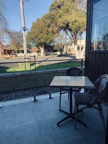 a table and two chairs sitting next to a building at Whittlesea Motel in Whittlesea