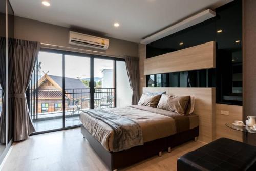 Ban Nong ChaengにあるPremiercondo Chonburi พรีเมียร์คอนโด ชลบุรีのベッドルーム(大型ベッド1台、大きな窓付)