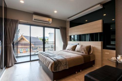 a bedroom with a large bed and a large window at Premier Luxe Hotel โรงแรมพรีเมียร์ลักซ์ in Ban Nong Chaeng