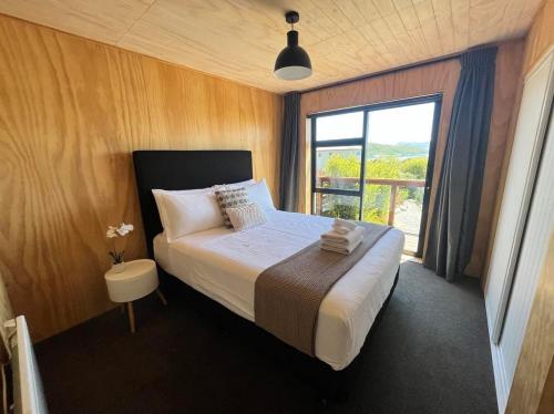 a bedroom with a large bed and a window at Wayfarers Lodge in Lake Tekapo