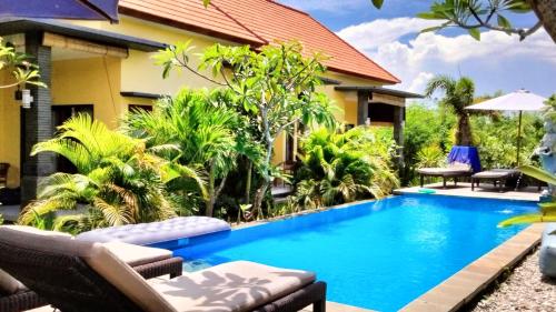 a swimming pool in front of a villa at Dream Beach Hostel Lembongan in Nusa Lembongan