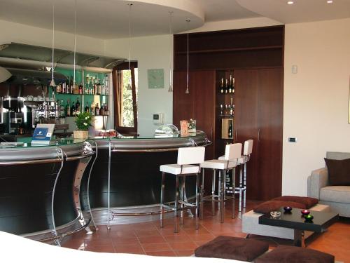 a bar in a living room with white stools at Maglioferro Residence in Corato
