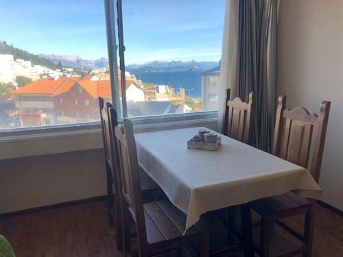 a table and chairs in a room with a large window at Studio Center Bariloche in San Carlos de Bariloche