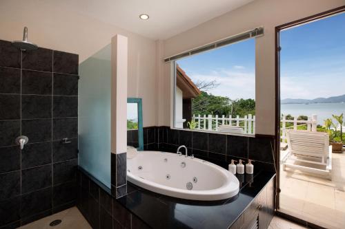 a bathroom with a tub and a view of the ocean at Soul Villas - Beachfront Private Pool Villas, Phuket Nature Retreat in Panwa Beach