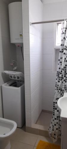 uma casa de banho branca com um chuveiro e um WC. em Recoleta Mediterráneo em Buenos Aires