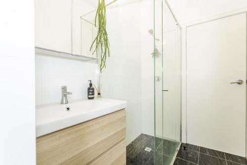 uma casa de banho com um lavatório e um chuveiro em Cottesloe Coastal Boho Retreat em Perth