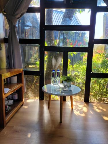 a table in the middle of a room with a window at Homestay Bản Búa in Mộc Châu