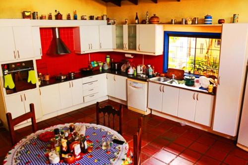 una cocina con armarios blancos y una mesa. en House in Barrio Herrera, en Asunción