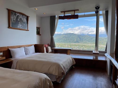 ein Hotelzimmer mit 2 Betten und einem großen Fenster in der Unterkunft Shangrila Leisure Farm in Dongshan