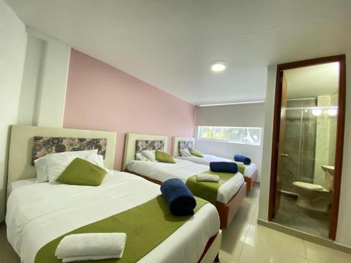 1 dormitorio con 2 camas y baño en Hotel Calantha, en Bogotá