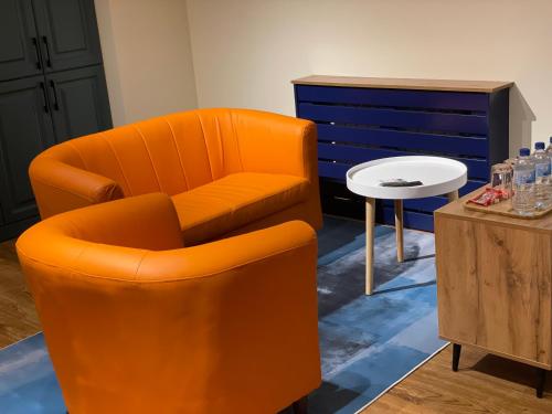 an orange chair and a table in a room at Covent Garden in Tashkent