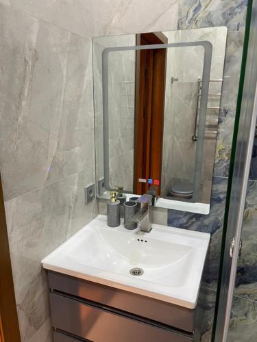 a bathroom with a white sink and a mirror at Covent Garden in Tashkent