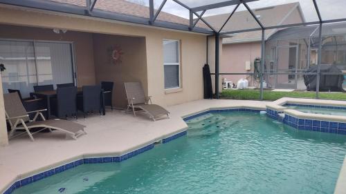 a swimming pool with chairs and a table in a house at Renovated 5 Bed/3 Bath Villa in Davenport