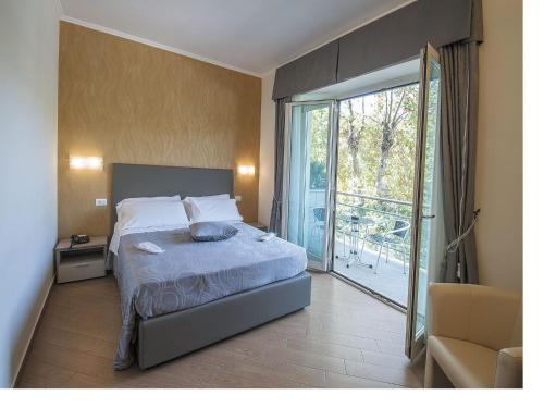 - une chambre avec un lit et une porte coulissante en verre dans l'établissement Porto Di Claudio, à Fiumicino