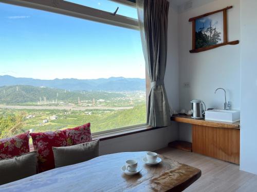 a dining room with a table and a large window at Shangrila Leisure Farm in Dongshan