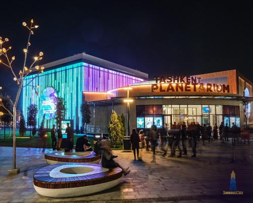 a building with people in front of it at night at Covent Garden in Tashkent