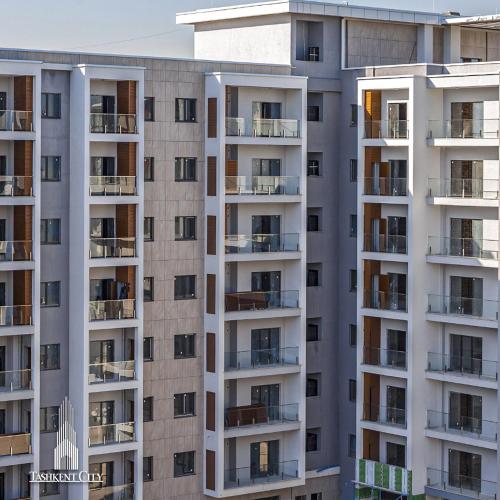 a tall apartment building with balconies at Covent Garden in Tashkent