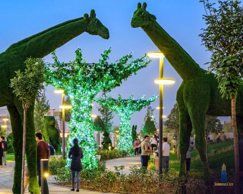 a group of giraffes in a park with lights at Covent Garden in Tashkent