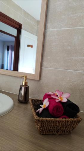 a bathroom counter with a basket with flowers on it at Mon oasis in Saint-Louis