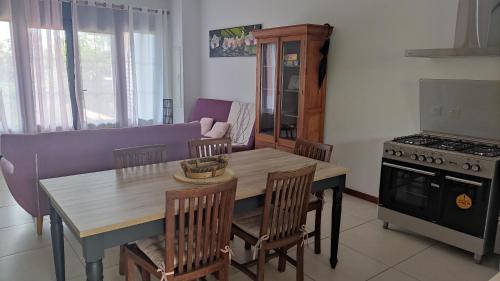 een keuken met een tafel en stoelen en een fornuis bij Mon oasis in Saint-Louis