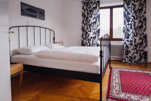 sypialnia z łóżkiem, oknem i dywanem w obiekcie Zimmer & Appartements in der Gamlitzerstrasse w mieście Ehrenhausen