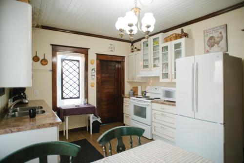 a kitchen with white appliances and a table and chairs at Character farmhouse set in beautiful countryside in Saskatoon