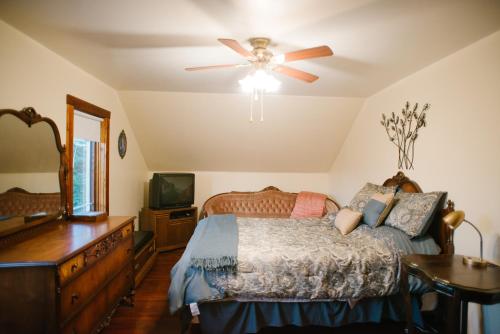 1 dormitorio con 1 cama y ventilador de techo en Character farmhouse set in beautiful countryside en Saskatoon