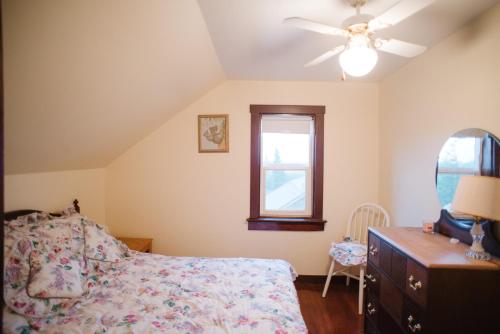 sypialnia z łóżkiem, komodą i oknem w obiekcie Character farmhouse set in beautiful countryside w mieście Saskatoon