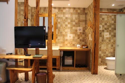 a bathroom with a television on a table with a toilet at Shangrila Leisure Farm in Dongshan